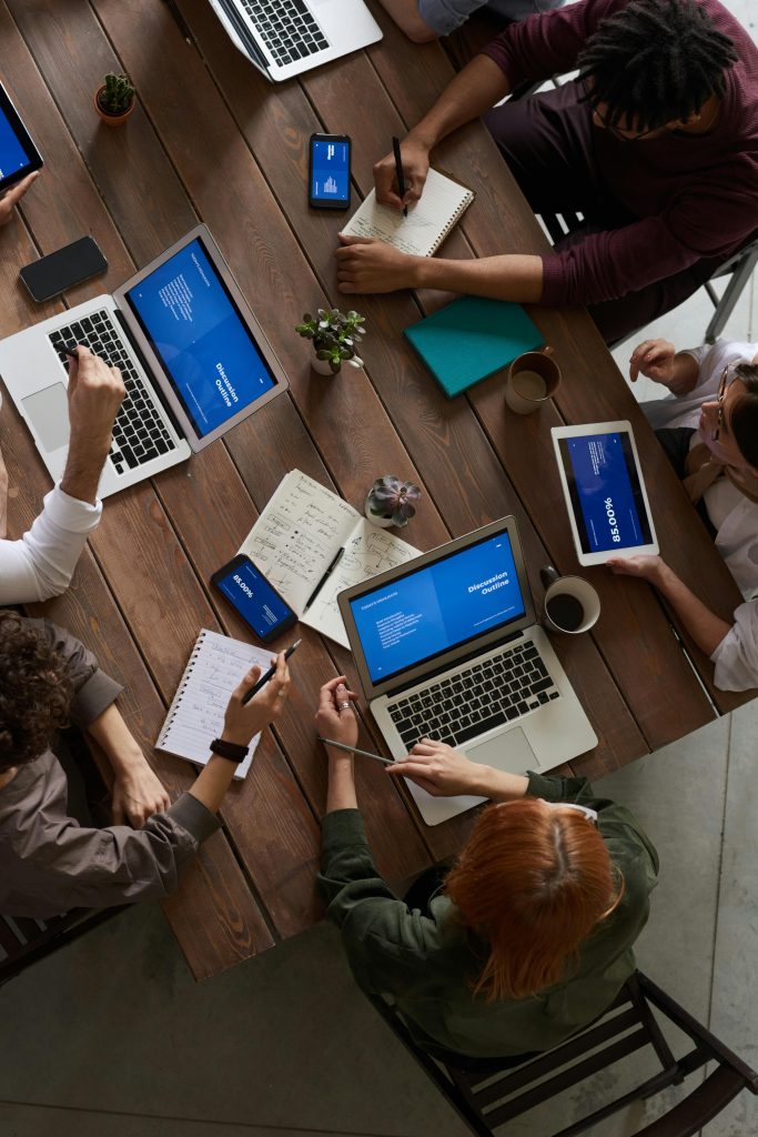pexels-photo-3183188-3183188 A diverse group of professionals brainstorming with laptops and notepads in a modern office.