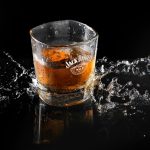 Dynamic shot of whiskey with ice and splash, highlighting Jack Daniel's brand on glass.